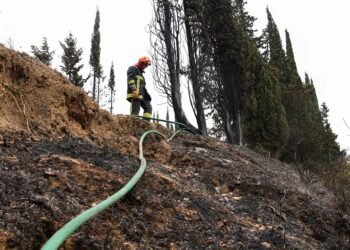 A firefighter works to prevent a wildfire from reigniting, in Fontjoncouse, southern France, August 6, 2025. REUTERS/Manon Cruz