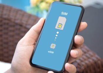 male hand holding phone with Sim card replacement on eSim in room house