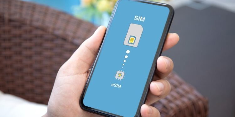 male hand holding phone with Sim card replacement on eSim in room house